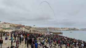 Cientos de personas esperan en la playa de la localidad de Fnideq (Castillejos) para cruzar los espigones de Ceuta.