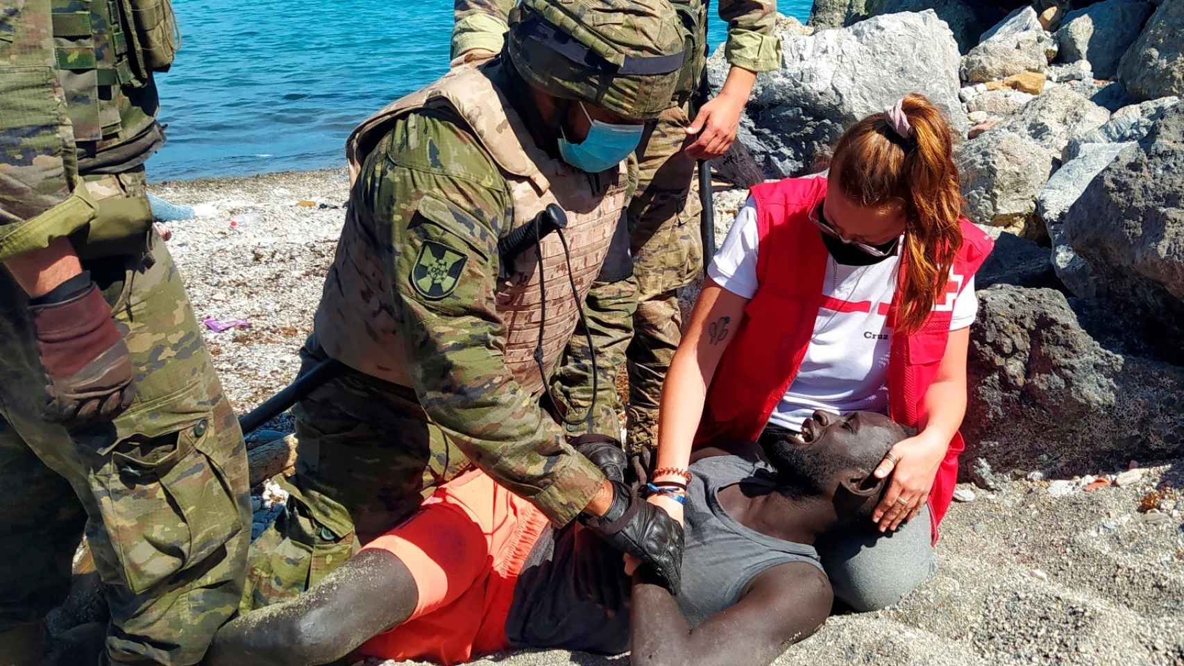 Luna, junto a miembros del Ejército, ayuda a un inmigrante que ha logrado cruzar uno de los espigones fronterizos de Ceuta este martes.
