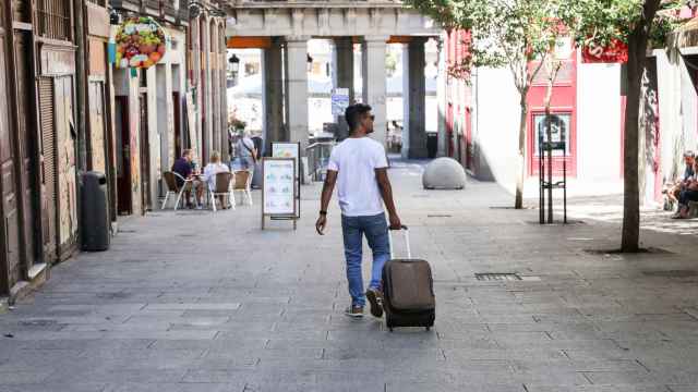 Un turista pasea con una maleta por el centro de Madrid.