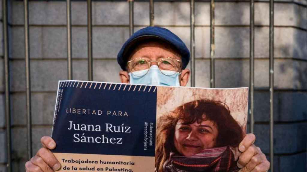 Un simpatizante de Juana Ruiz sostiene su foto en la manifestación del 29 de abril frente a la embajada de Israel en Madrid.