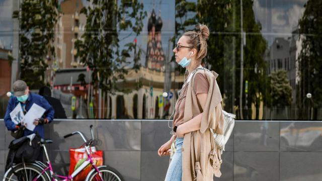 Una mujer pasea por las calles de Moscú con la mascarilla bajada.