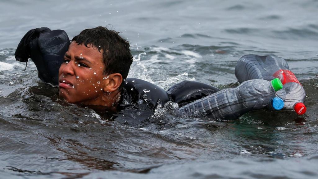 Un menor marroquí trata de alcanzar la playa de Ceuta