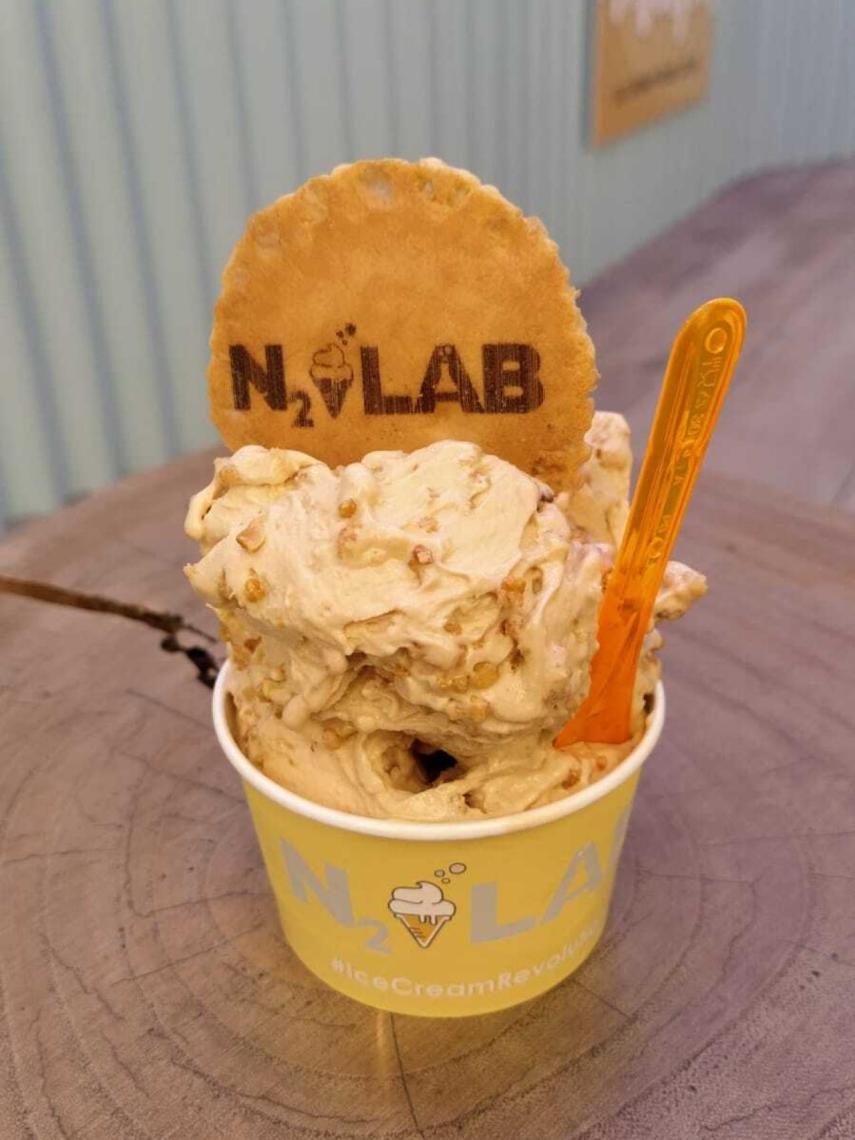 La tarrina de helado de N2 Lab, que contiene una bola de helado de caramelo con un 'topping'.