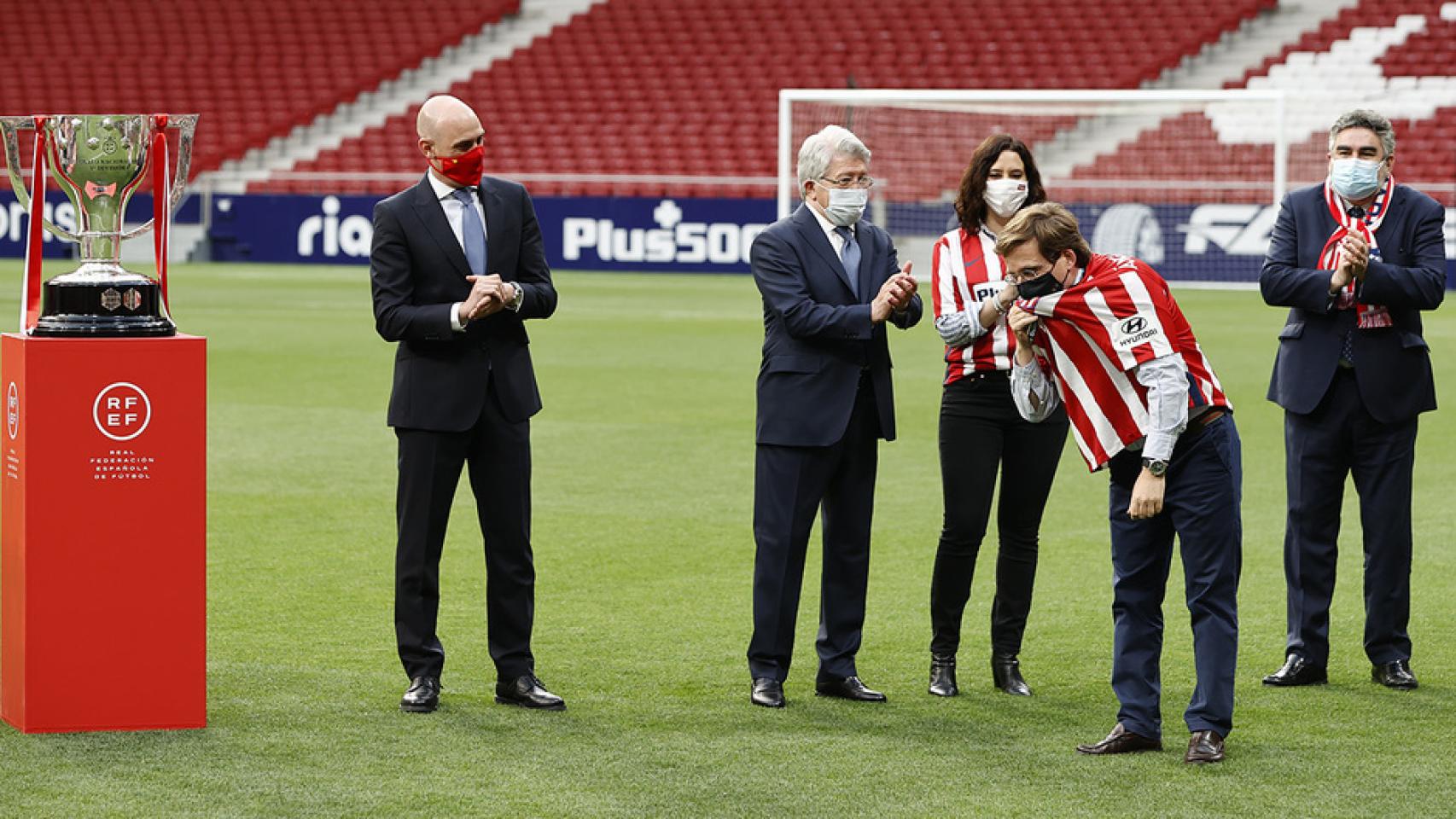 Almeida se besa el escudo del Atlético frente a la mirada de Rubiales, presidente de la RFEF, Enrique Cerezo, Isabel Díaz Ayuso y el ministro Rodríguez Uribes