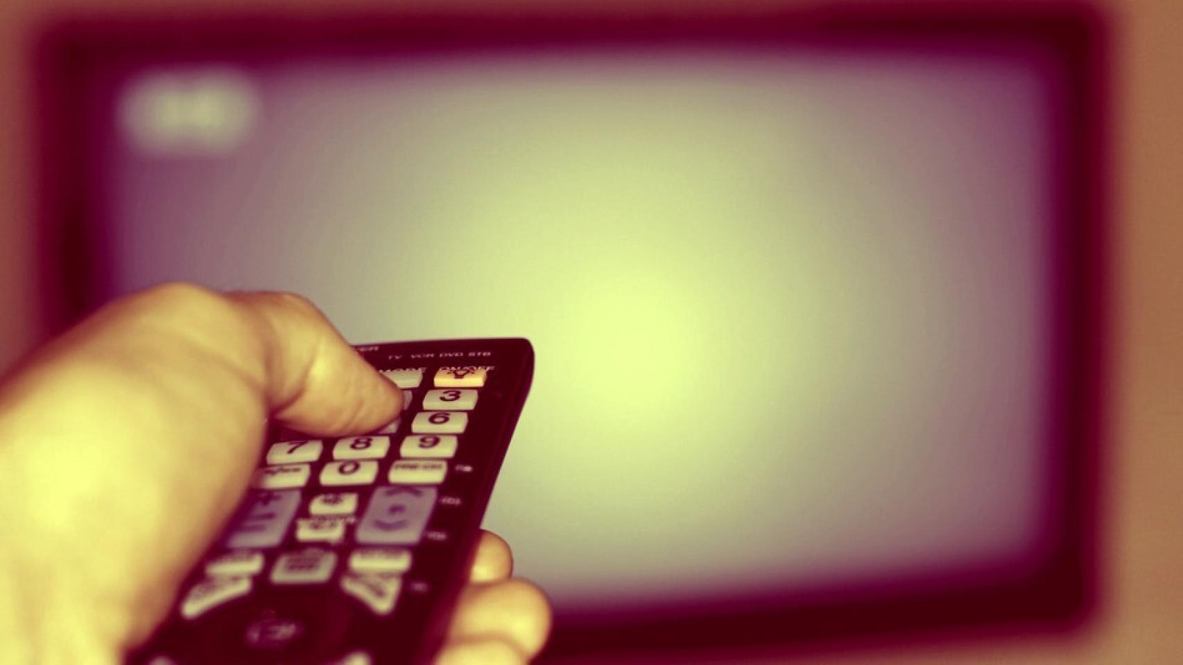 Un usuario apunta a una televisión con un mando a distancia.