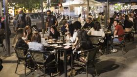 Varios jóvenes sentados en una terraza en la La Latina, zona típica de tapas y copas de Madrid.