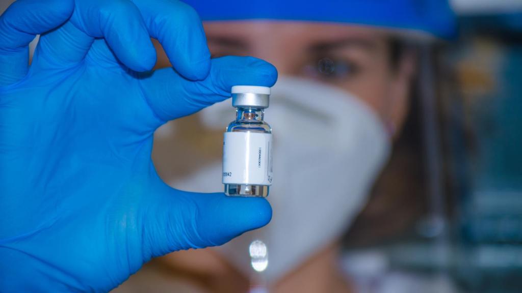 Sanitario con un vial de AstraZeneca.
