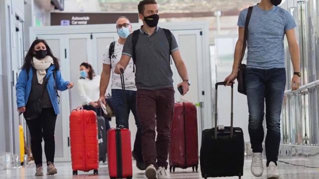 Turistas llegando a un aeropuerto.