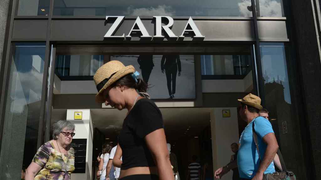Una chica pasea por delante de una tienda de Zara.