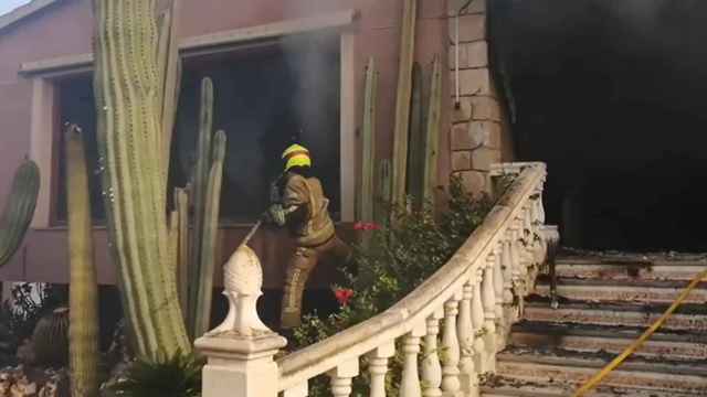 Momento en el que los bomberos entran en el domicilio en llamas.