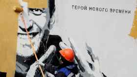 Un trabajador borra un mural de Navalny.