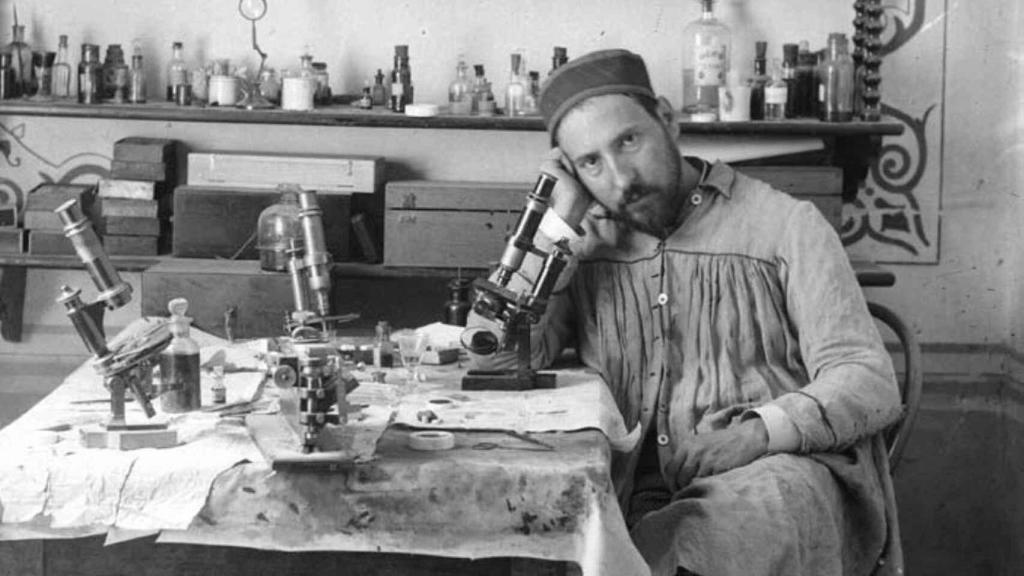 Ramón y Cajal junto a un microscopio en su despacho.