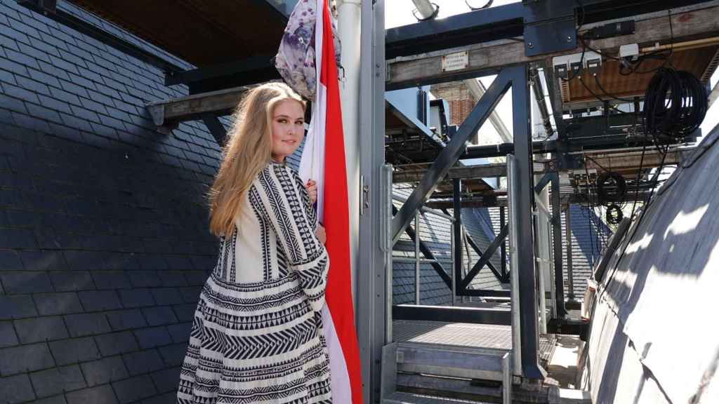 Amalia de Holanda, izando la bandera de su país, para celebrar su graduación.