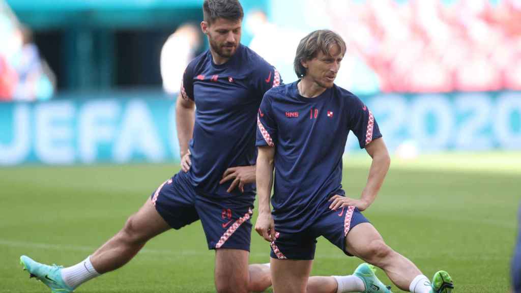 Modric realiza ejercicios de estiramientos junto a Petkovic