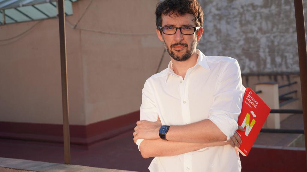Juan Milián posa junto a un ejemplar de su libro.