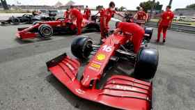 Mecánicos de Ferrari miran los monoplazas de Leclerc y Sainz