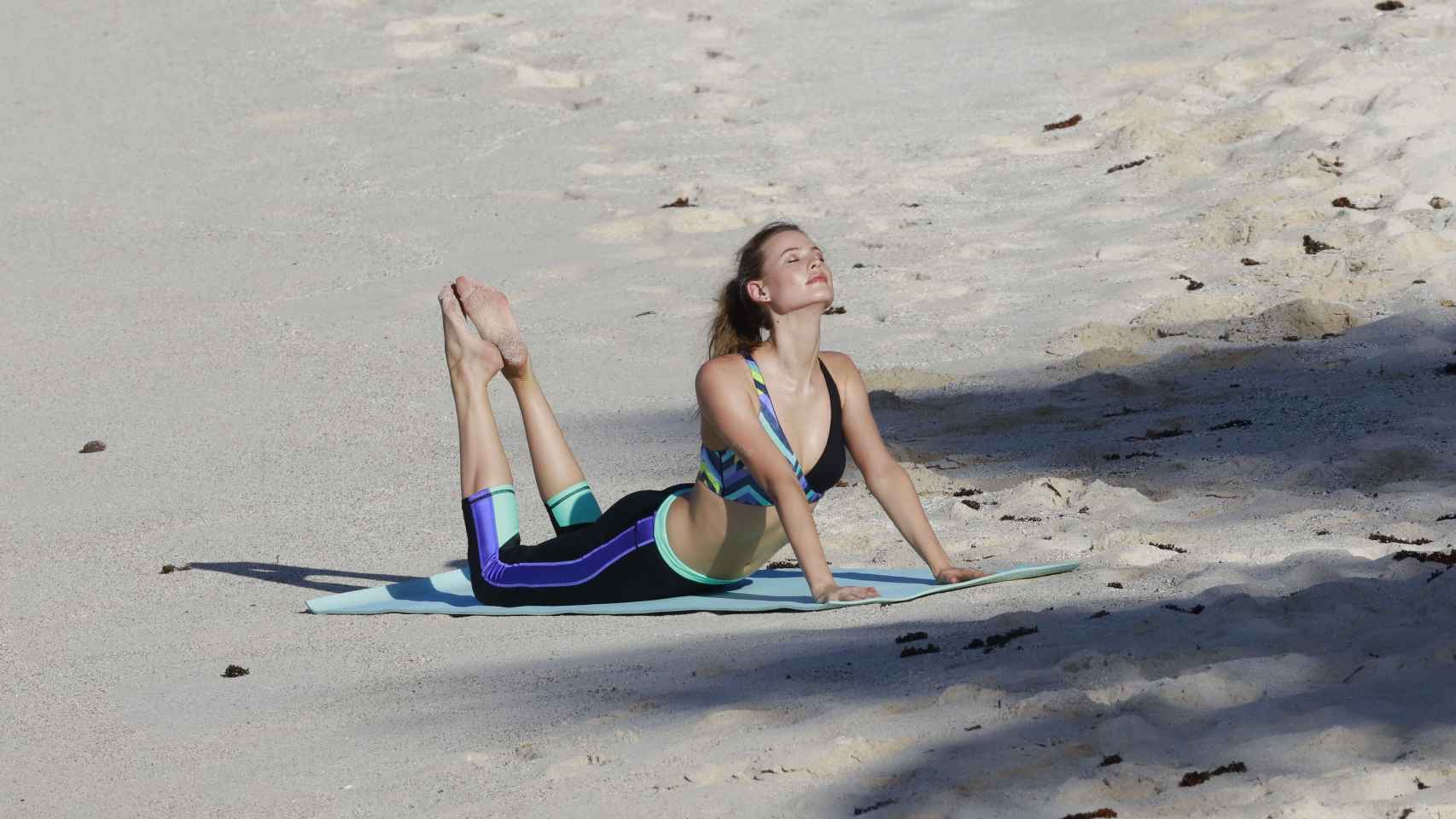 La modelo Martha Hunt haciendo pilates en la playa.