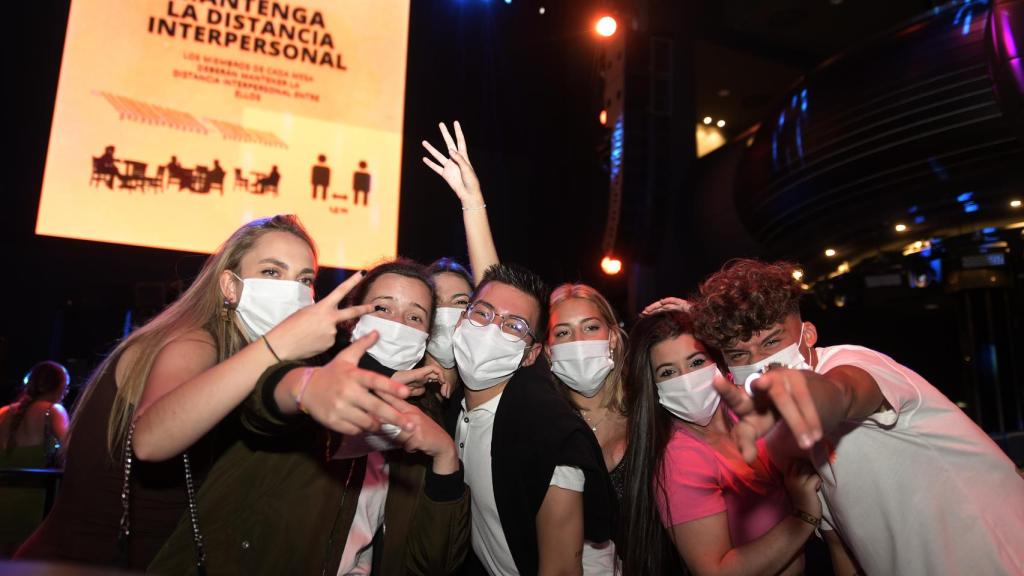 Un grupo de jóvenes usa la mascarilla dentro de una discoteca.