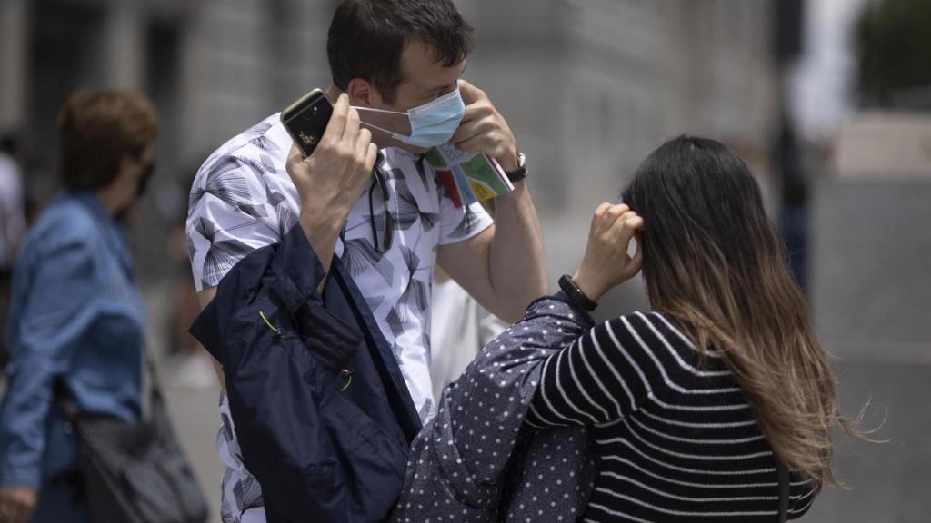 Dos jóvenes con mascarilla.
