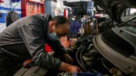 Imagen de un mecánico trabajando en un coche.