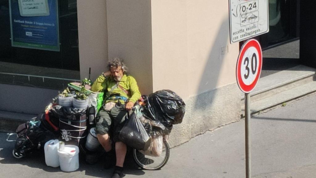 Fernando, durmiendo sobre su bicicleta en una calle de Milán.