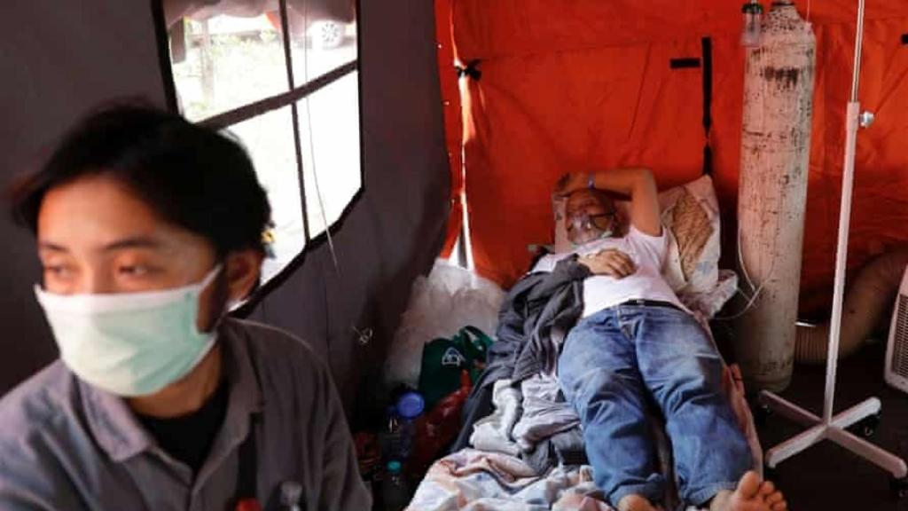 Un paciente de Covid-19 descansa en una tienda temporal fuera de la sala de emergencias de un hospital en Yakarta, Indonesia.