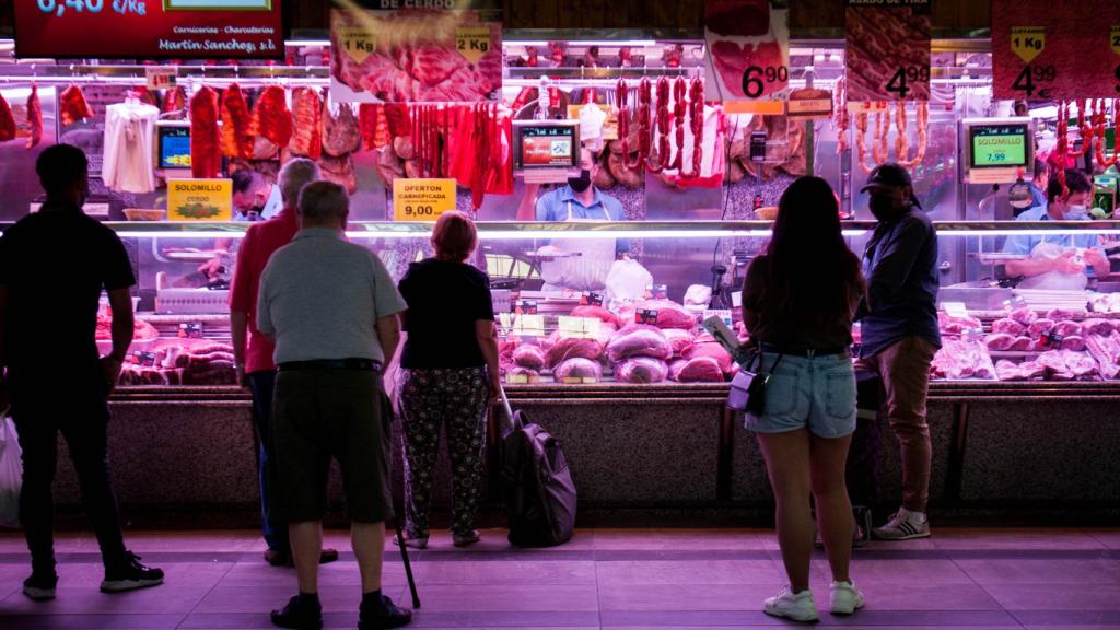 Varias personas hacen cola en una carnicería del Mercado de las Maravillas de Madrid.