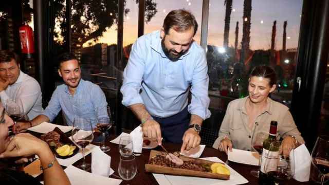 Paco Nuñez cortando una pieza de carne durante una cena con alcaldes del PP