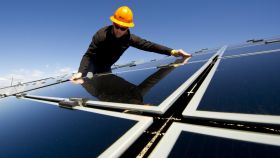 Un operario instalando paneles solares.