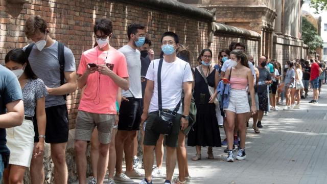 Centenares de personas hacen cola en el Hospital de Sant Pau de Barcelona para vacunarse.