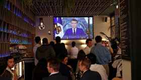 Franceses en un bar durante el discurso del presidente, Emmanuel Macron, de este lunes. Efe