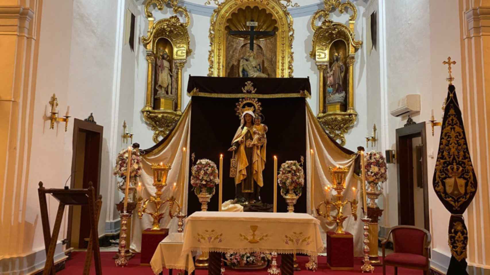 La Virgen del Carmen de El Palo presidiendo el altar mayor, preparada para su festividad.
