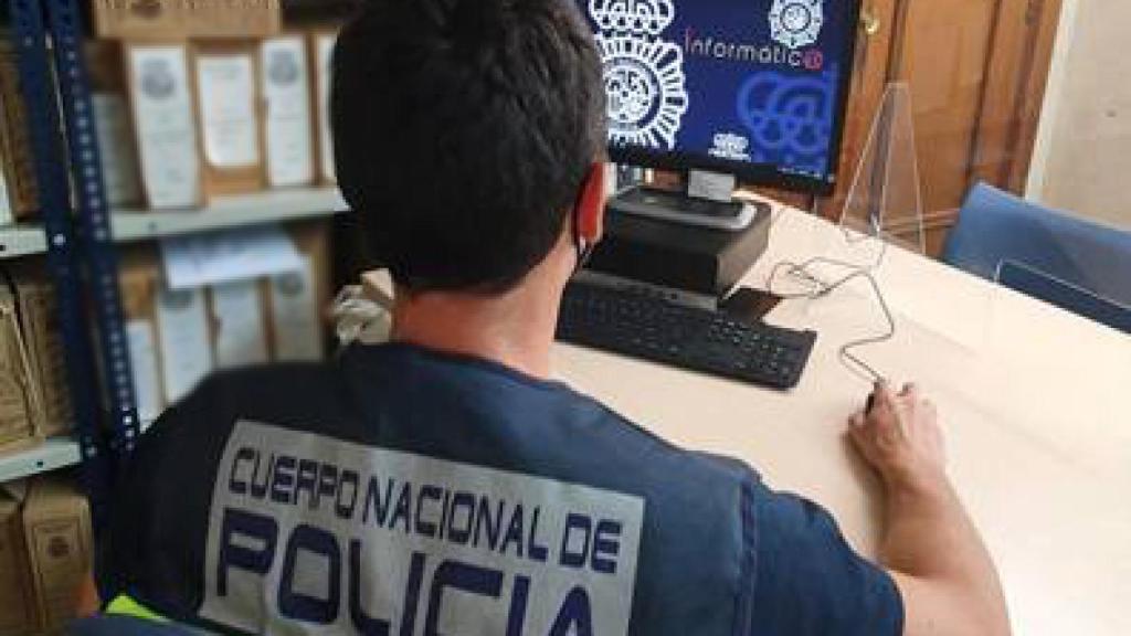 Un agente de la Policía Nacional delante de su ordenador.