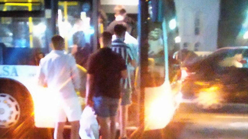Un grupo de jóvenes se sube al autobús con bolsas con botellas para hacer botellón en la playa.