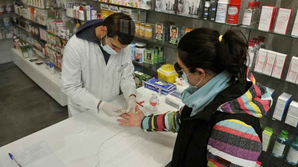 Un farmacéutico realiza una prueba serológica de Covid-19 en una Farmacia de Galicia.