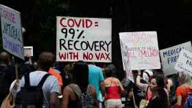 La recuperación del Covid es del 99% sin vacuna, dice la pancarta de unos manifestantes en Nueva York.