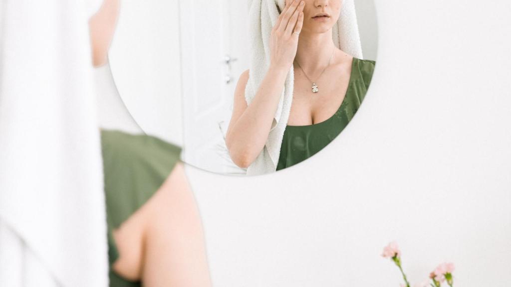 Chica aplicando su rutina de belleza facial.