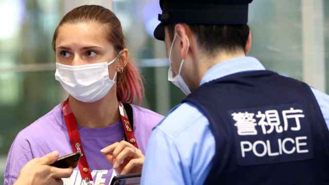 La atleta bielorrusa Krystsina Tsimanouskaya habla con agentes de policía en el aeropuerto de Haneda en Tokio.