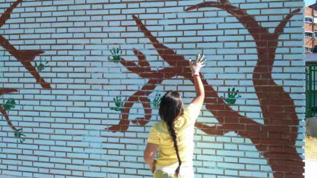 Una niña del barrio de Pajarillos pinta un mural