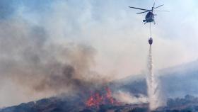 Los bomberos tratan de sofocar un incendio originado al prenderse un vehículo en Ávila.