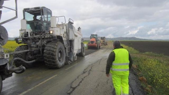 Maquinaria y un operario asfaltando una carretera