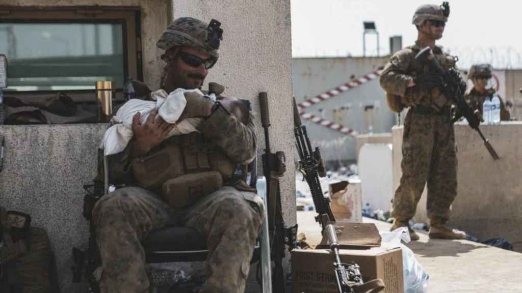 Un marine acuna a un bebé en medio de la crisis afgana.