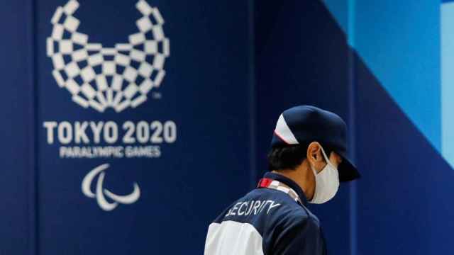 El logo de los Juegos Paralímpicos de Tokio 2020 detrás de un empleado