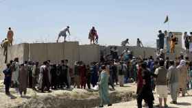 Afganos se agolpan a lo largo del muro del aeropuerto internacional Hamid Karzai, en Kabul. Efe