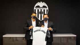 Marcos André y Anil Murthy posa con la camiseta del Valencia tras su fichaje