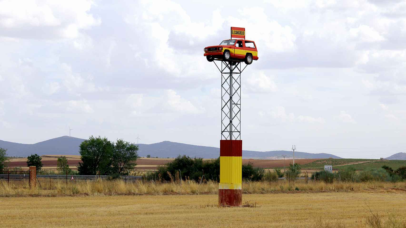 Un coche pintado con la bandera de España se ve desde la carretera y localiza El Cangrejo.