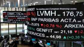 FILE PHOTO: Company stock price information, including that for LVMH Moet Hennessy Louis Vuitton SA, is displayed on screens as they hang above the Paris stock exchange, operated by Euronext NV, in La Defense business district in Paris