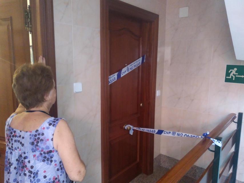 A neighbor of Camelia, this Monday, observing the seal of the apartment where the murder took place.