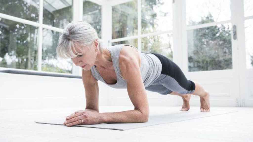 Una mujer realiza una plancha en el gimnasio.