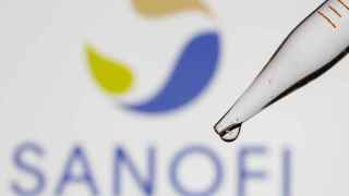 A test tube is seen in front of a displayed Sanofi logo in this illustration